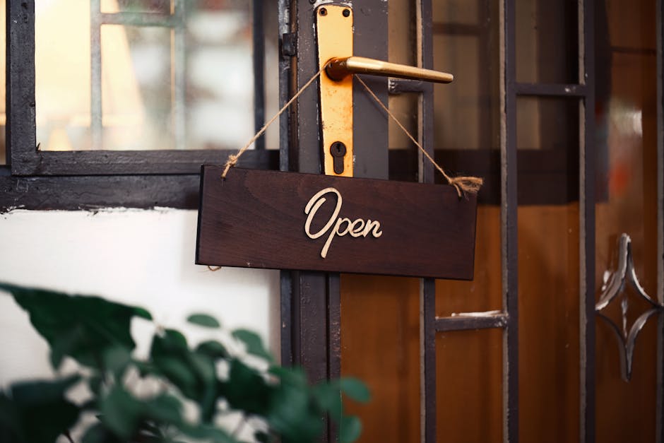 Wooden 'Open' sign hanging on a rustic door, inviting entry.